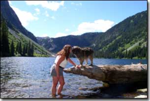 Briard-Artemis giving Barbara a kiss by a lake in BC