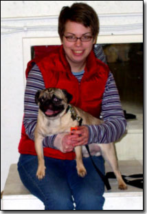 Manners class owner holding her pug and smiling
